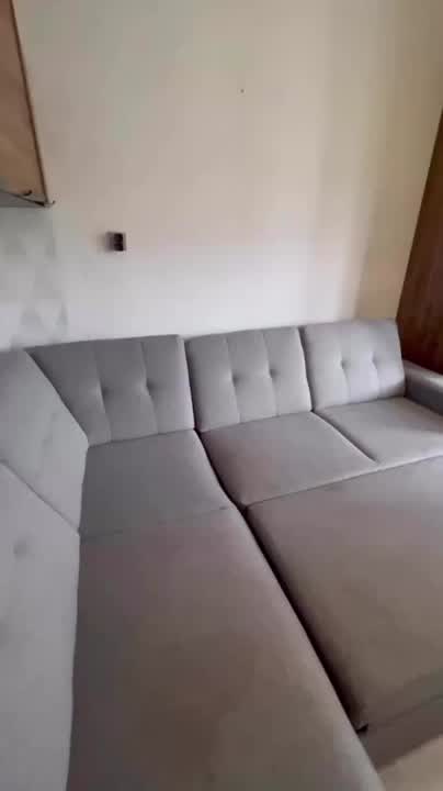 Canapé d’angle en tissu gris lors d’une intervention filmée par l’équipe.