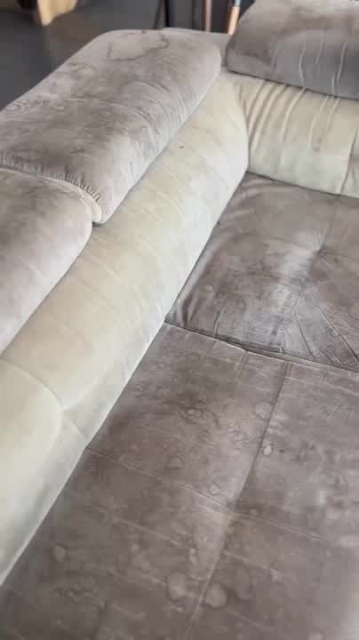 Assise d’un canapé en tissu clair marquée par des taches, avant nettoyage.