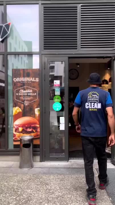 Intervenant Clean Wash Home devant un commerce après le nettoyage d’un tapis, image extraite d’une vidéo publiée